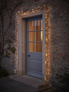 the front door is lit up with fairy lights