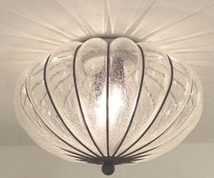 a glass light fixture hanging from the ceiling