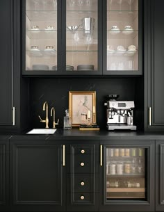 a kitchen with black cabinets and gold trim on the glass doors, white plates and silverware