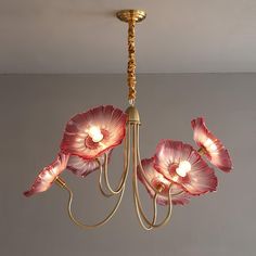 a chandelier with pink flowers hanging from it's center and two lights on each side