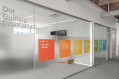 an office with glass walls and colorful signs