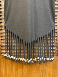 the back of a black t - shirt with white beads on it