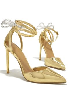 A sparkling bow dial up the glamour of a pointy-toe stiletto in a sleek metallic finish. • Pointed Toe• Ankle Strap• Blinged Out Bow Detail• 4" Heel Gold Heels Wedding, Gold Shoes Heels, Heels Aesthetic, Stylish Heels, Embellished Heels, Chic Heels, Pump Heels, Prom Heels, Wedding Palette