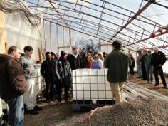 a group of people standing around in a greenhouse