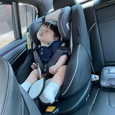 a young boy sleeping in the back seat of a car