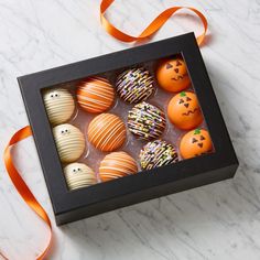 a box filled with assorted decorated chocolates on top of a marble countertop