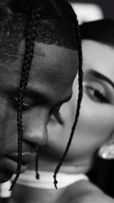 a man with dreadlocks kissing a woman's forehead in black and white