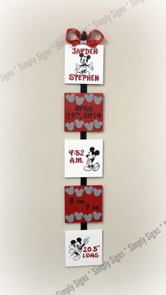 mickey mouse name tags are hanging on a wall with red and white polka dot ribbon