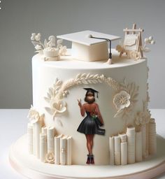 a white cake decorated with an image of a woman holding a book and graduation cap