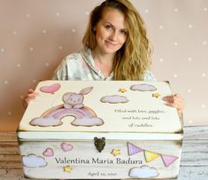 a woman holding up a wooden box with an image of a teddy bear on it