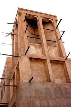 a tall brown building with lots of wires attached to it