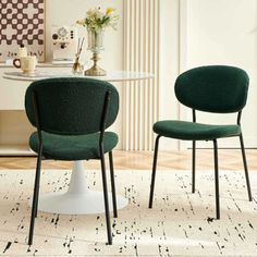 two green chairs sitting next to each other on top of a white rug in front of a table