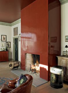 a living room with a fire place in the center and red walls on both sides