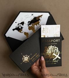 a hand holding a passport next to an envelope with a world map on the front