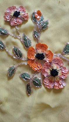 an image of some flowers that are on a table cloth or bed sheet with beads and sequins