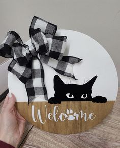 a wooden sign with a black cat on it and the words welcome written in white