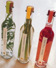 three bottles with flowers in them sitting on a table