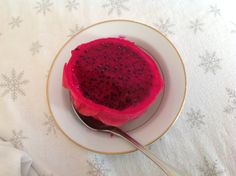 a plate that has some kind of fruit on it with a spoon in the bowl