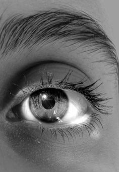 an eye with long lashes and no makeup is shown in this black and white photo