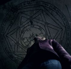 a person writing on a wall with an astro wheel in the background