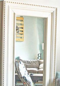 a mirror that is sitting on top of a table in front of a couch and coffee table