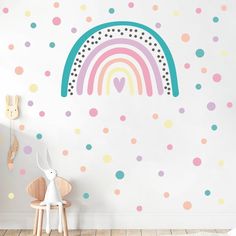 a child's room with polka dot wall decals and a rainbow painted on the wall