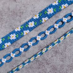 two blue and white beaded bracelets sitting next to each other on a gray surface