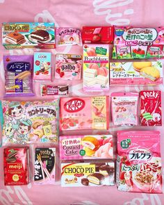 many different types of candy on a pink background with japanese characters written in white letters