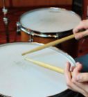 a person is playing drums with sticks in their hands