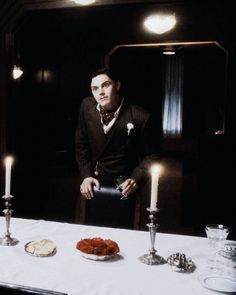 a man sitting at a table with candles in front of him