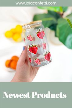 a hand holding a glass jar with strawberries on it