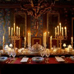 a fancy dining table with candles and plates