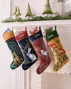 christmas stockings hanging from a mantel in front of a fireplace