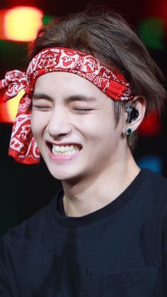 a young man wearing a red bandana and smiling