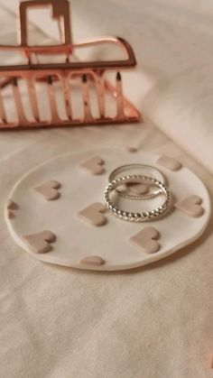 two wedding rings are placed on a tray next to an ironing board with hearts