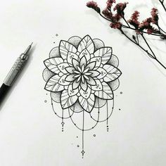 a drawing of a flower on paper next to a pen