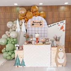 a dessert table with balloons and decorations on the wall behind it in a room that has wood paneled walls