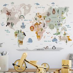 a child's room with a large wall mural featuring animals and the world map