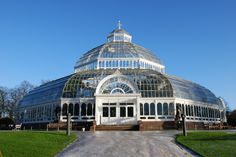 a large glass building in the middle of a park