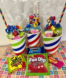 candy buckets filled with candies and lollipops on a table