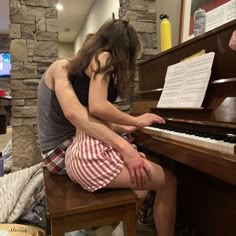 a man and woman are sitting at a piano playing the music on it's own