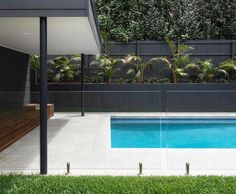 an empty swimming pool in the middle of a backyard with grass and trees around it