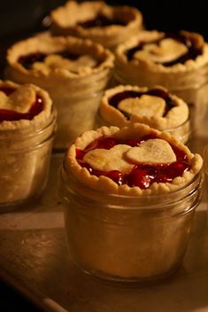 several small pies in glass jars on a table