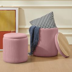 two pink stools and one black and white checkerboard pillow on the floor