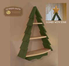 a wooden christmas tree shelf sitting on top of a wall next to a sign that says come with star