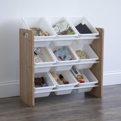 a book shelf with several bins on the top and bottom, in front of a white wall