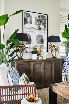 a living room filled with lots of furniture and plants on top of a wooden table