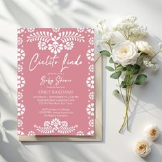 a pink and white wedding suite with flowers on the table next to it is an elegant card