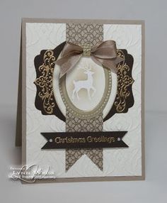 a white card with a brown ribbon and a deer on it's side, in front of a gray background