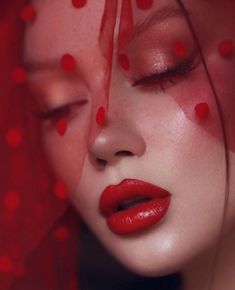 a woman with her eyes closed wearing red lipstick and mesh netting covering her face, close up